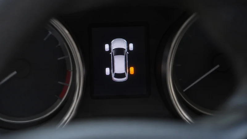 Dashboard TPMS display showing four tire pressure readings with one tire reading higher after hot highway driving
