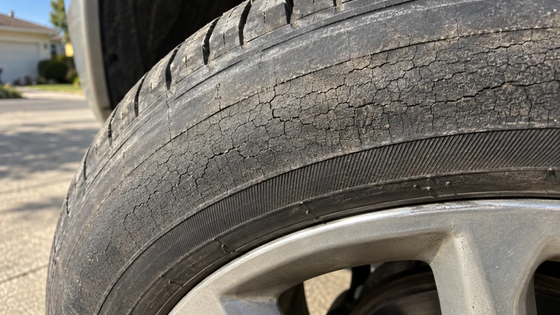 An aging tire sidewall covered in fine dry-rot cracks