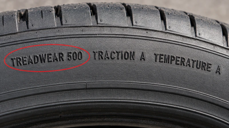 Close-up of a tire sidewall with the UTQG TREADWEAR grade circled