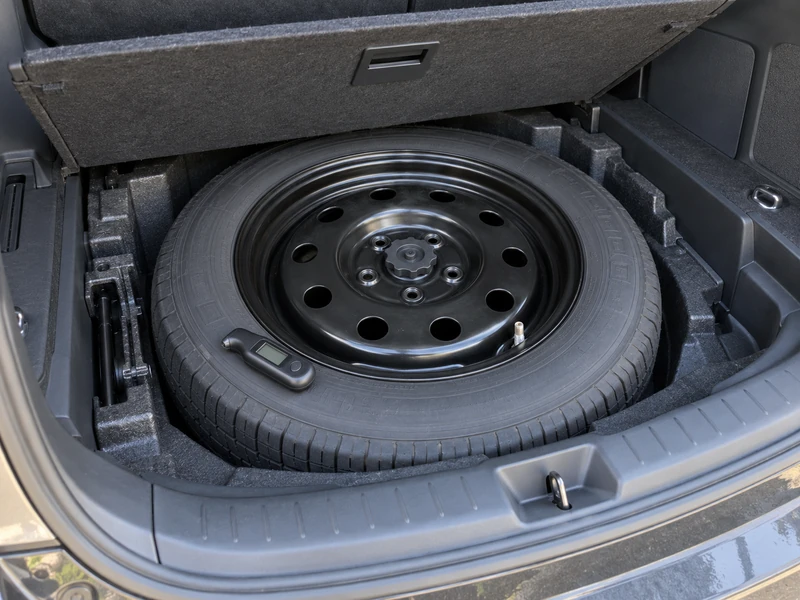 A Toyota spare tire in the trunk with a TPMS sensor valve stem visible