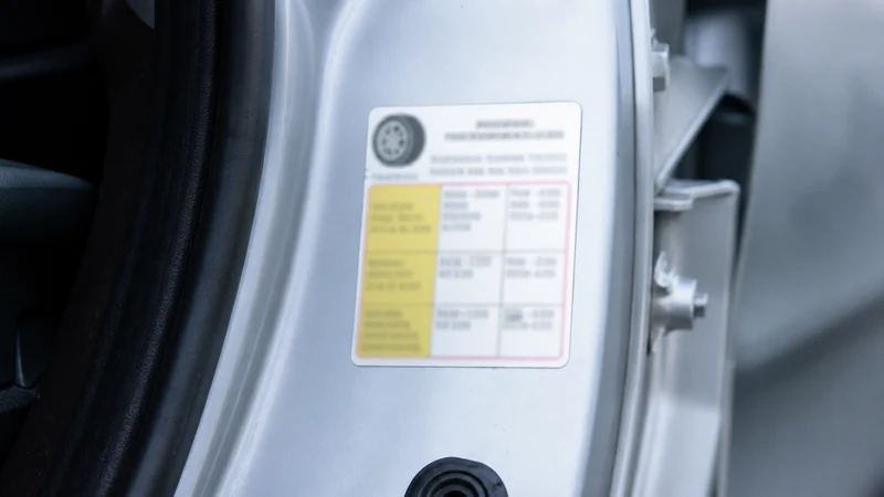 Close-up of the tire pressure sticker on a driver-side door jamb showing the recommended cold winter tire pressure